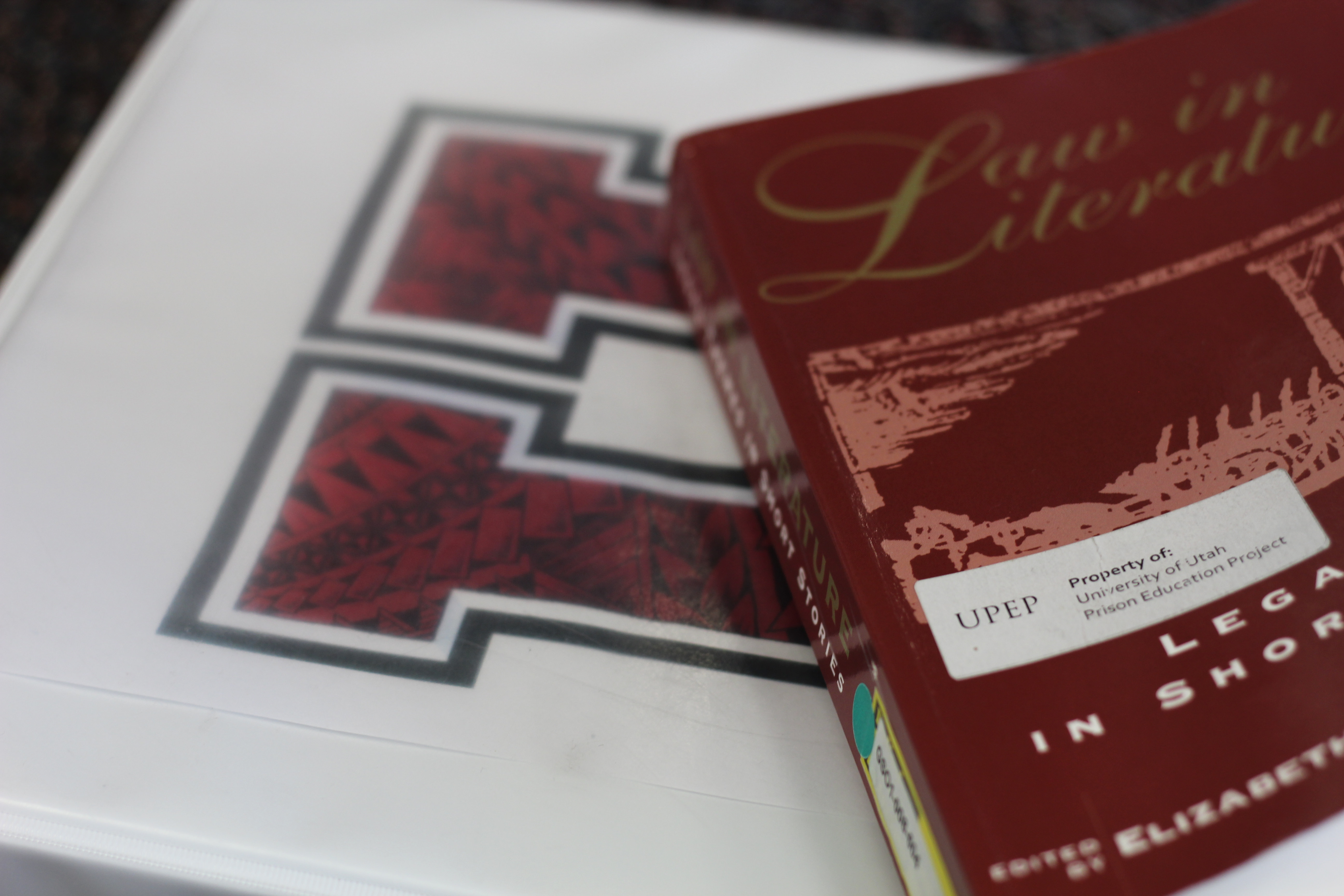 Notebook with a "U" and a Law & Literature textbook.